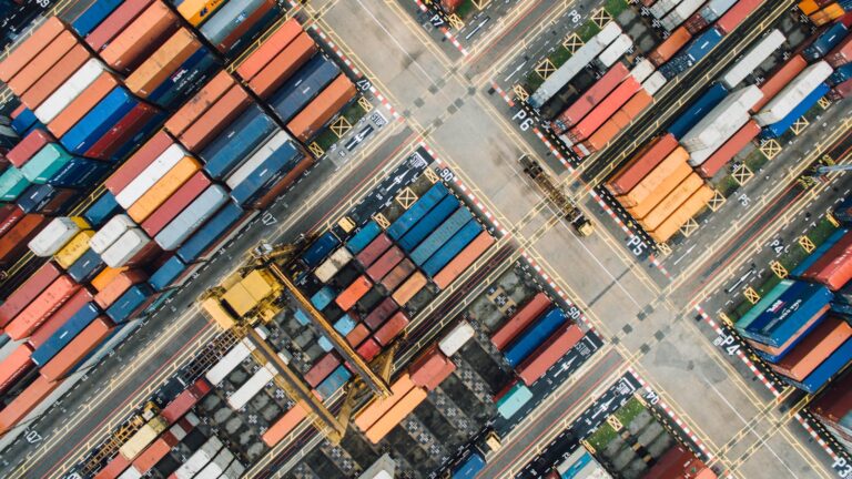 Aerial view of a stacked shipping container yard representing hidden tier 2 supplier visibility risk in the supply chain