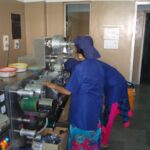 Pharmaceutical manufacturing staff operating a blister packaging machine on a production line