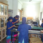Pharmaceutical packing line staff inspecting finished products for supply chain compliance