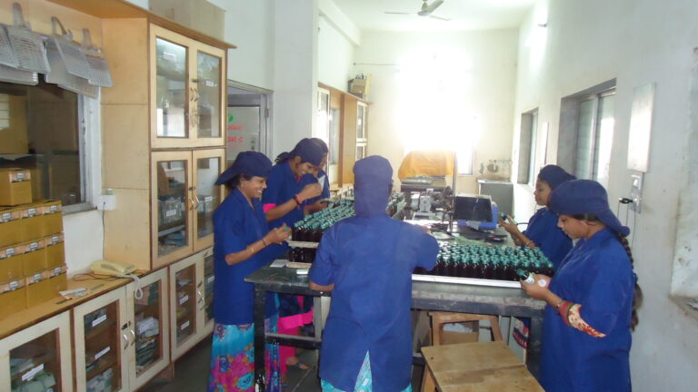 Pharmaceutical packing line staff inspecting finished products for supply chain compliance