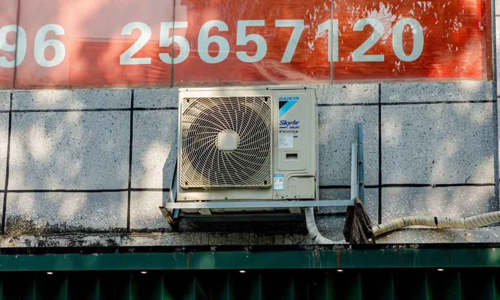 Technician servicing an HVAC compressor unit during the A2L refrigerant transition