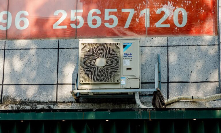 Technician servicing an HVAC compressor unit during the A2L refrigerant transition