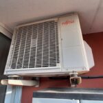 Industrial HVAC compressor and condenser units on a commercial building, representing supply chain risk in HVAC procurement