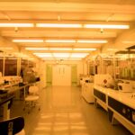Technician inspecting sterile precision components on a medical device cleanroom assembly line