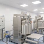 Stainless steel reactor vessels in a pharmaceutical manufacturing facility, illustrating how to monitor tier 2 suppliers of APIs and key starting materials
