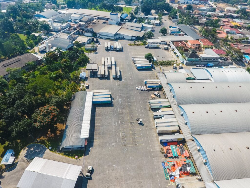 Aerial view of a dairy processing plant and distribution yard with trucks, illustrating tier 2 supplier visibility risk in food and beverage supply chains