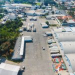 Aerial view of a dairy processing plant and distribution yard with trucks, illustrating tier 2 supplier visibility risk in food and beverage supply chains