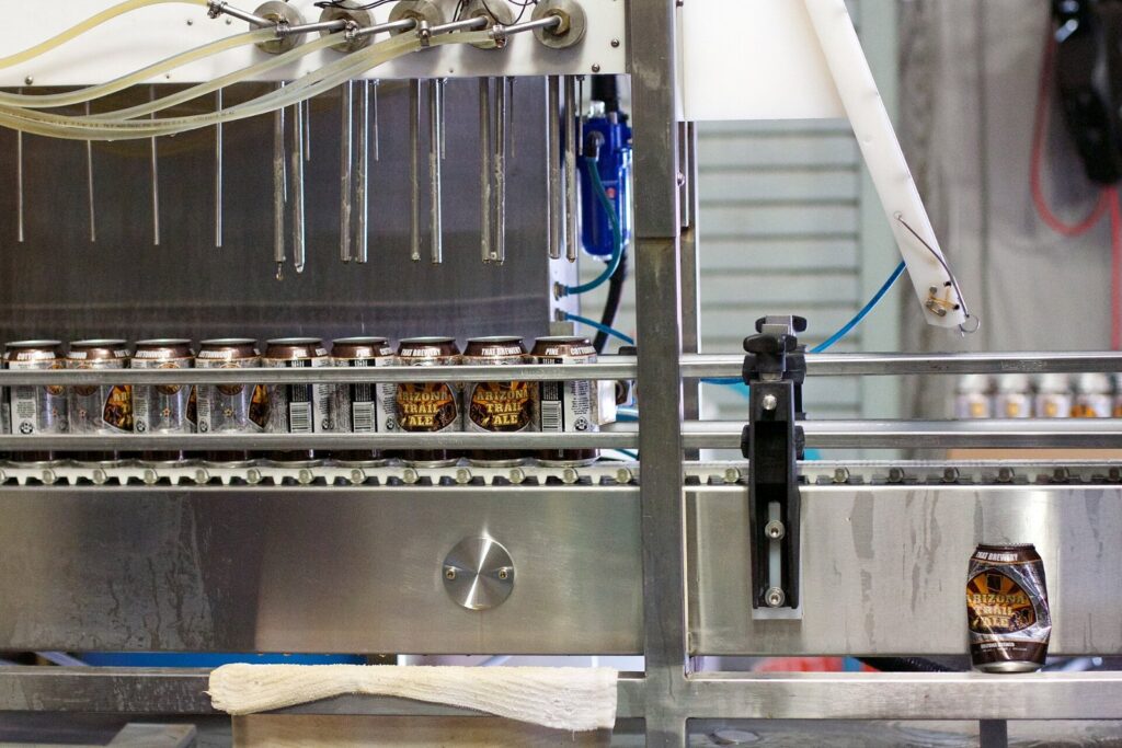 Beverage canning line filling aluminum cans, illustrating supply chain tariff impact on food and beverage packaging procurement