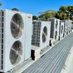 Rows of rooftop HVAC condenser units on a commercial building, illustrating state refrigerant regulations and HVAC supplier compliance risk