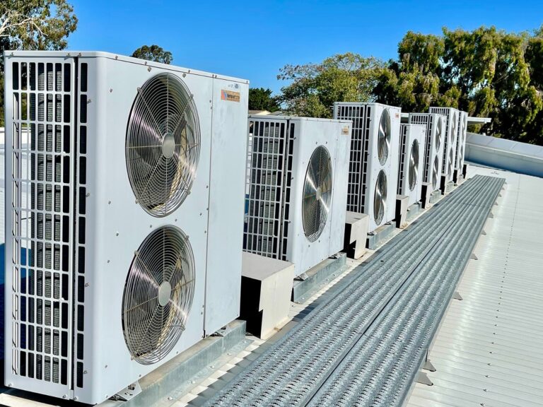 Rows of rooftop HVAC condenser units on a commercial building, illustrating state refrigerant regulations and HVAC supplier compliance risk