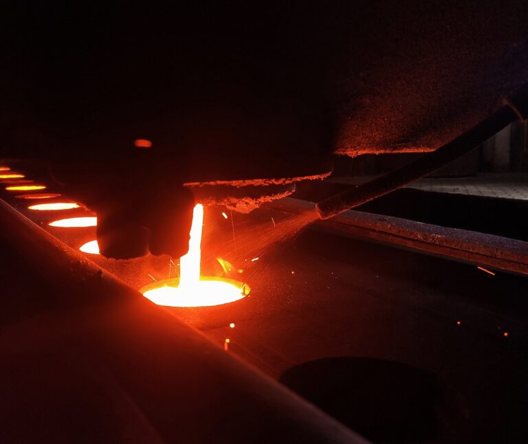Molten cast iron poured into a sand mold at a metal foundry, illustrating signs a supplier is in financial trouble in industrial machinery sourcing