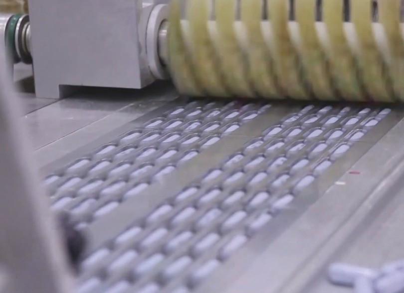 Tablets moving along a pharmaceutical production line, illustrating API supplier qualification risk and drug shortage exposure